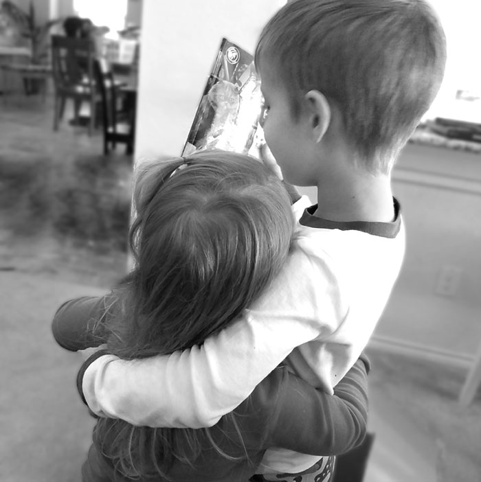 Two young children hugging