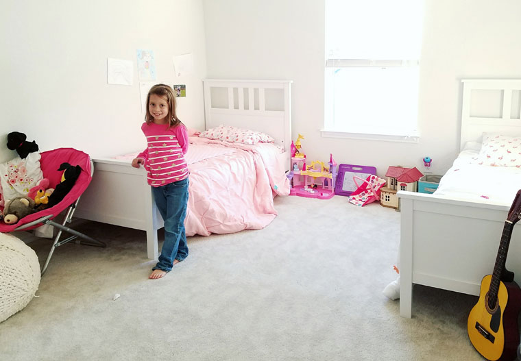 Girl standing her clean bedroom