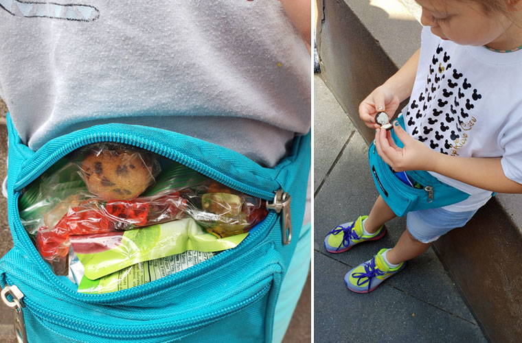 Child eating snacks from a waist pack in a line at Disneyland