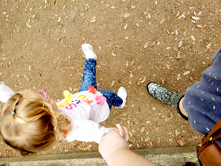 Mom and child holding hands.