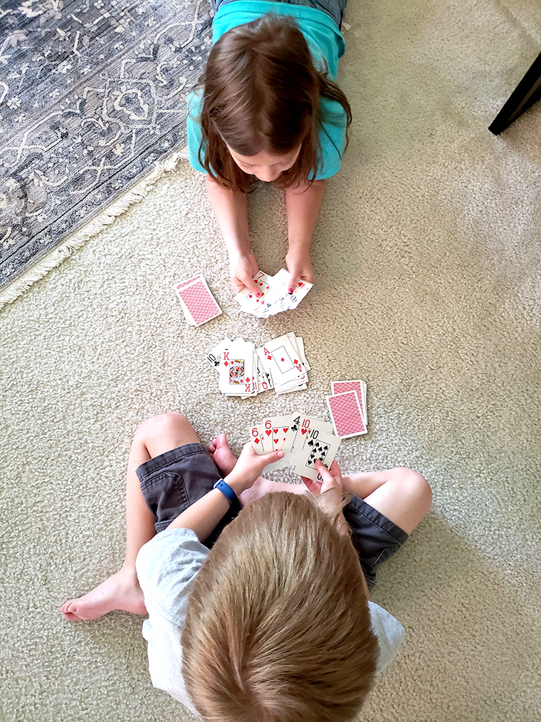 Kids playing a card game on the floor