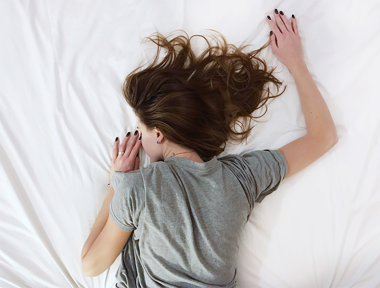 Tired woman laying in bed.