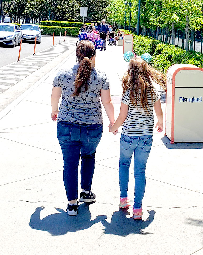 Mom and daughter holding hands.