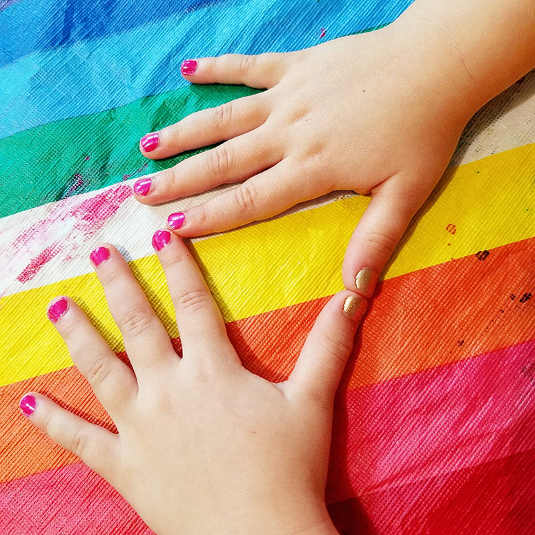 Child's hands with painted fingernails.