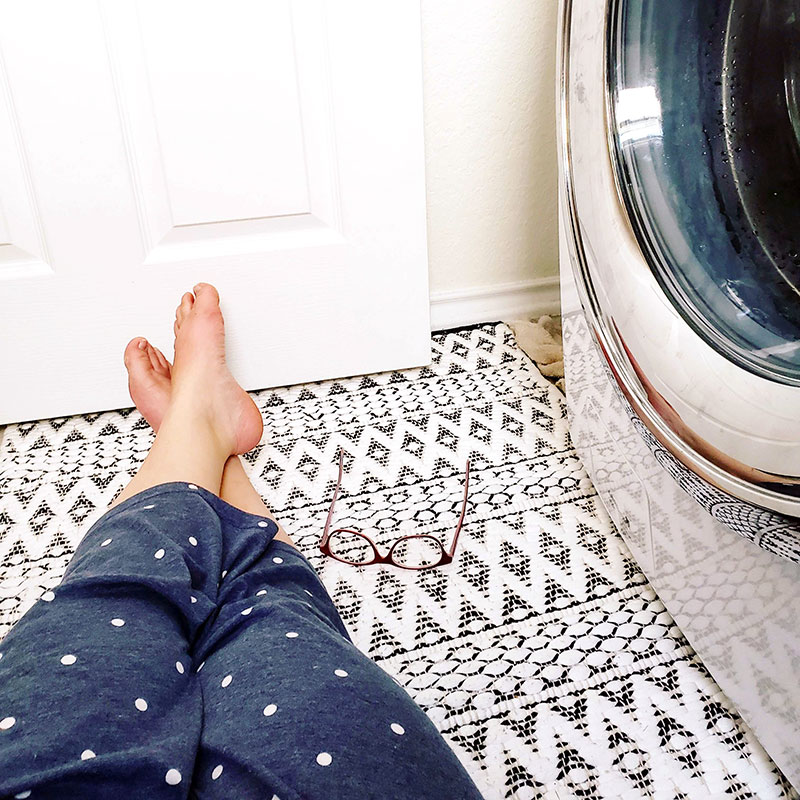 Woman sitting in laundry room.