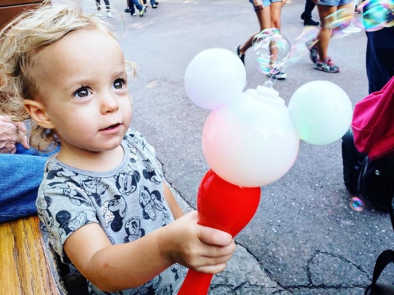 Toddler playing with Mickey Mouse bubble wand.