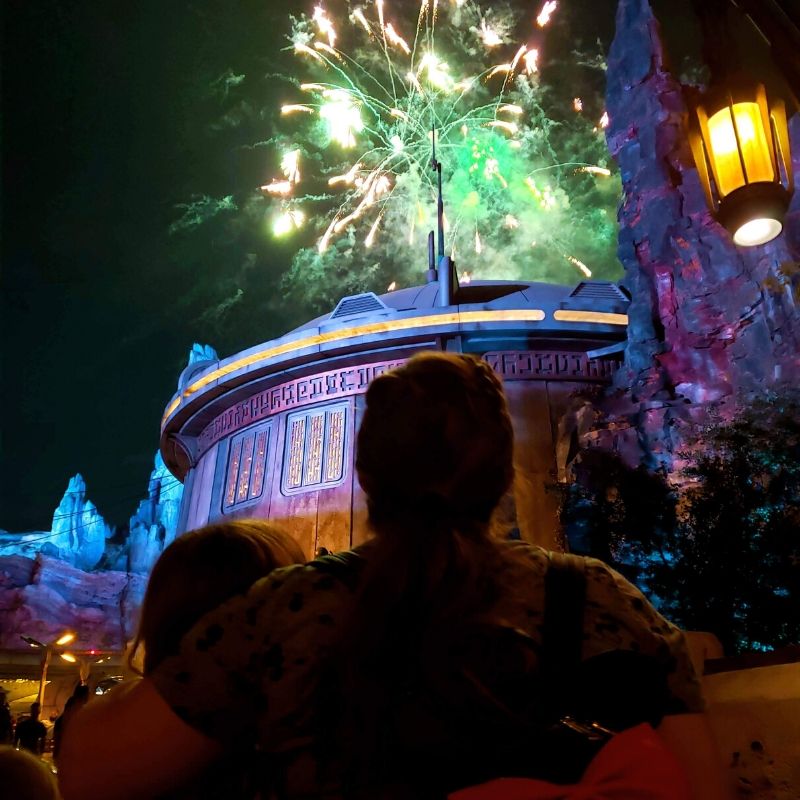 Mom and daughter watching fireworks at Star Wars Galaxy's Edge.